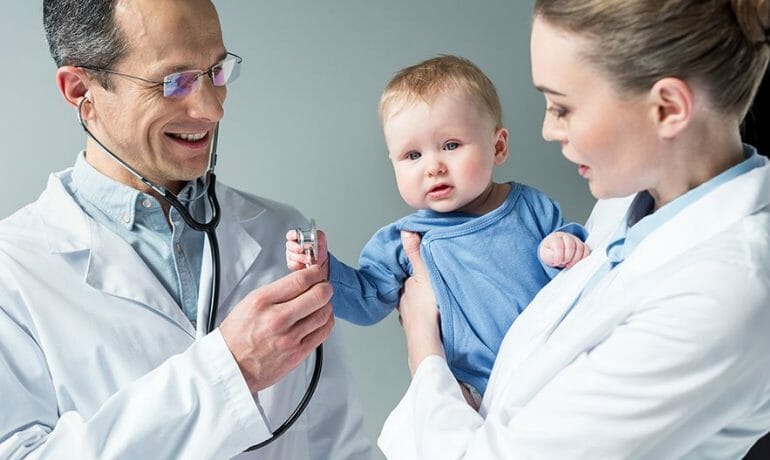 pediatricians checking breath of adorable little baby